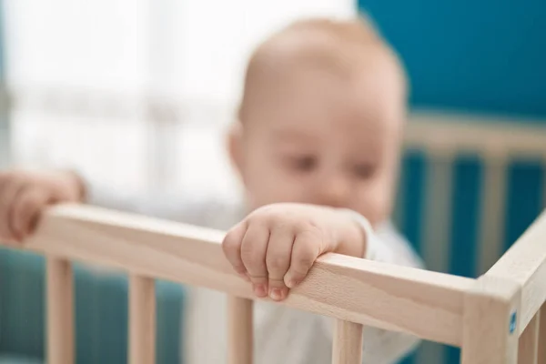 可爱的高加索婴儿站在卧房的摇篮上 — 图库照片