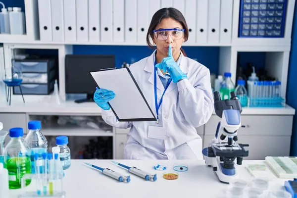 Hispanic Young Woman Working Scientist Laboratory Asking Quiet Finger Lips — ストック写真