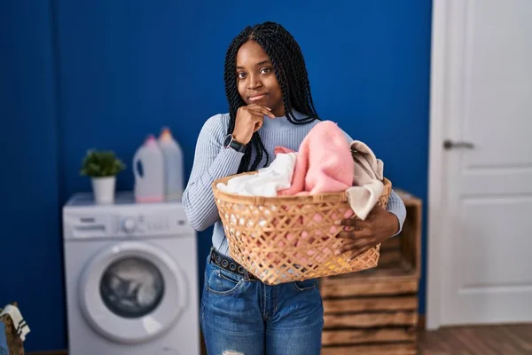 Afrikansk Amerikansk Kvinna Håller Tvättkorg Allvarligt Ansikte Tänker Fråga Med — Stockfoto