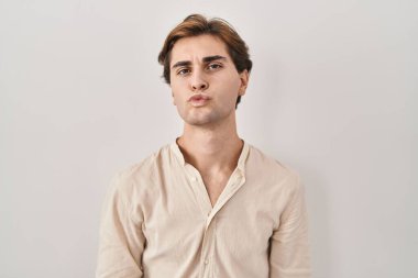 İzole edilmiş arka planda duran genç adam canlı yayında öpüşürken kameraya bakıyor. Güzel ve seksi. aşk ifadesi. 