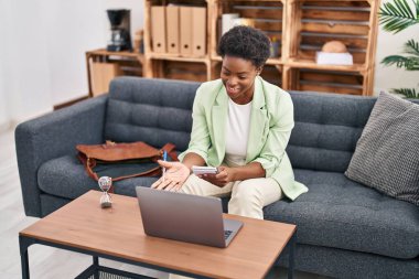 Afrika kökenli Amerikalı kadın psikolog, psikoloji merkezindeki kanepede oturuyor.