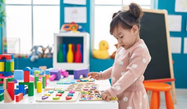 Anaokulunda matematik oyunu oynayan sevimli Çinli kız.