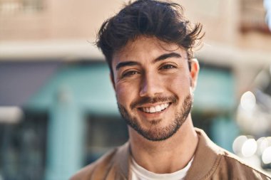 Sokakta kendinden emin gülümseyen İspanyol genç adam.