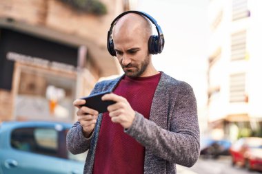 Sokakta video oyunu oynayarak kendine güvenen genç adam