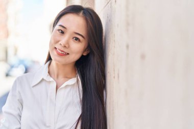 Young chinese woman smiling confident standing at street