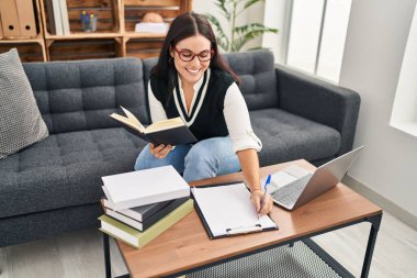 Genç, güzel İspanyol iş kadını. Ofiste kitap okuyor.