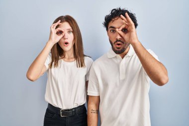 Gündelik giysiler giymiş genç bir çift birlikte hareket ediyor. Şaşırmış bir ifade, parmaklarından bakan gözler. İnançsız ifade. 