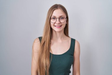 Young caucasian woman standing over white background with a happy and cool smile on face. lucky person. 