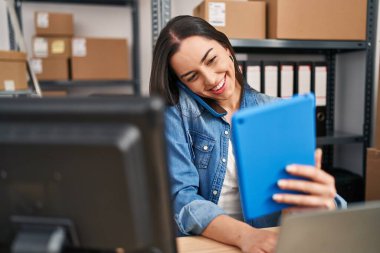 Young beautiful hispanic woman ecommerce business worker working at office
