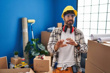 Sakallı, evde çalışan genç İspanyol bir adam. Tamir edilmiş yüz ifadesi, tiksindirici bir ifade, tiksinti ifadesi, tiksinti ifadesi.. 