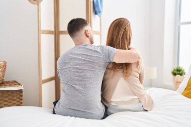 Man and woman mother and son hugging each other sitting on bed at bedroom
