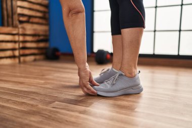 Orta yaşlı kadın spor merkezinde geriniyor.