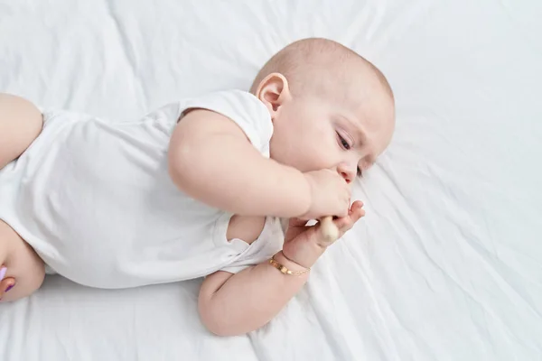 Sevimli Beyaz Bebek Yatakta Uzanıyor Yatak Odasında Maraca Oyuncağı Emiyor — Stok fotoğraf