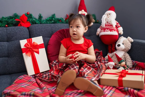 愛らしいです中国の女の子ホールディングボール座っています上のソファによってクリスマス装飾で家 — ストック写真