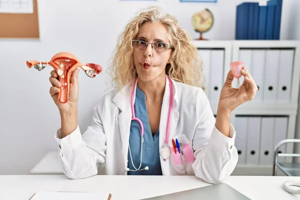 Médico Mediana Edad Mujer Sosteniendo Copa Menstrual Haciendo Cara Pez —  Fotos de Stock