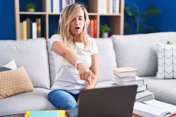 Young Blonde Woman Studying Using Computer Laptop Home Pointing Displeased — Stok fotoğraf