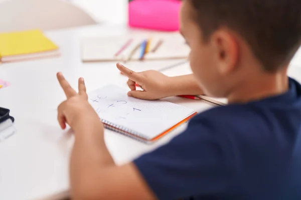 可敬的是 他那惊慌失措的幼儿在课堂上用手指数数做数学练习 — 图库照片