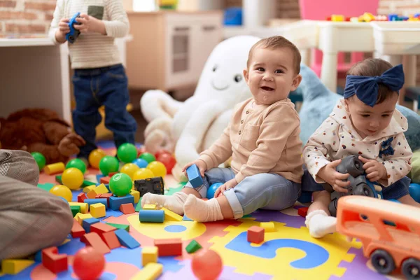 Dwa Maluchy Bawiące Się Zabawkami Siedzącymi Podłodze Przedszkolu — Zdjęcie stockowe