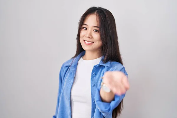 Ung Kinesisk Kvinna Står Över Vit Bakgrund Ler Glad Erbjuder — Stockfoto