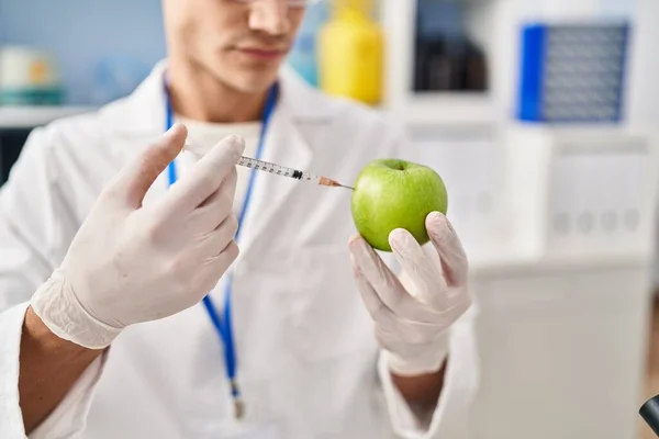 Young Hispanic Man Wearing Scientist Uniform Injecting Apple Laboratory — ストック写真