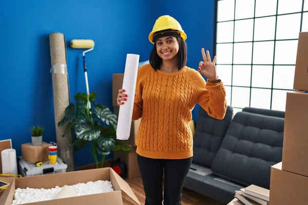 Young Hispanic Woman Standing New Home Blueprints Doing Sign Fingers — Stockfoto