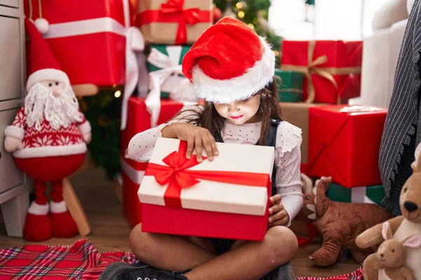 Adorable Hispanic Girl Unpacking Gift Sitting Floor Christmas Tree Home — Stok fotoğraf