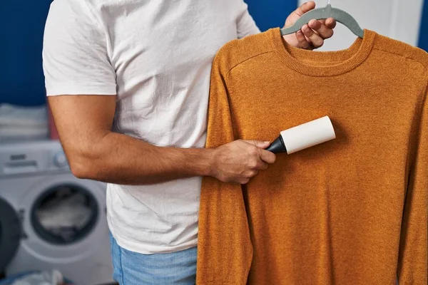 Çamaşır odasında kuaförle süveter temizleyen İspanyol genç adam.