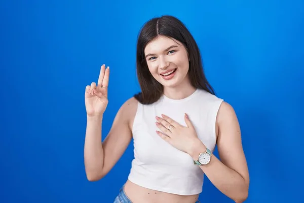 Young Caucasian Woman Standing Blue Background Smiling Swearing Hand Chest — Stockfoto
