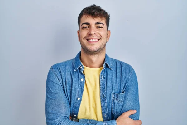 Young Hispanic Man Standing Blue Background Happy Face Smiling Crossed — Stockfoto