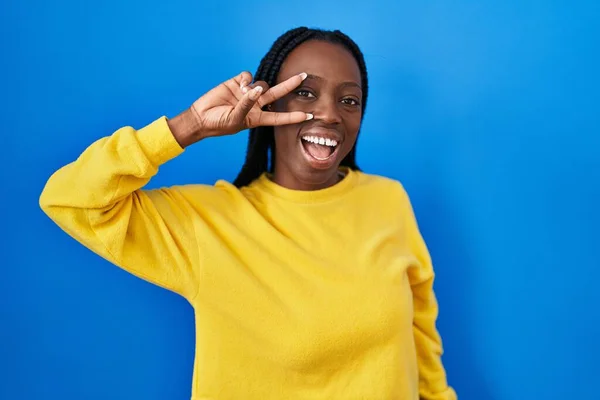 Güzel Siyah Kadın Mavi Arka Planda Duruyor Barış Sembolü Yapıyor — Stok fotoğraf
