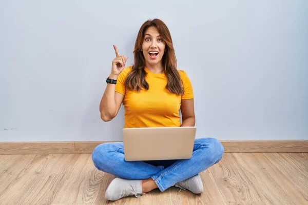 Hispanic Woman Using Laptop Sitting Floor Home Pointing Finger Successful —  Fotos de Stock