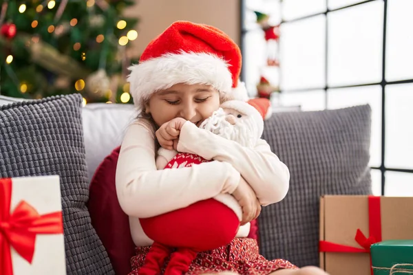 Adorável Hispânico Menina Abraçando Papai Noel Brinquedo Sentado Sofá Pela — Fotografia de Stock