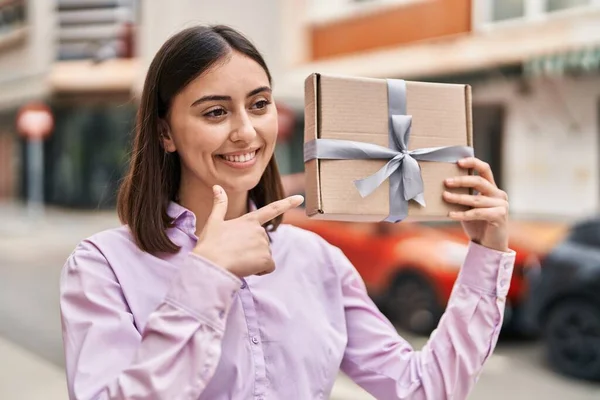 Young Hispanic Woman Smiling Confident Pointing Finger Gift Package Street — Φωτογραφία Αρχείου
