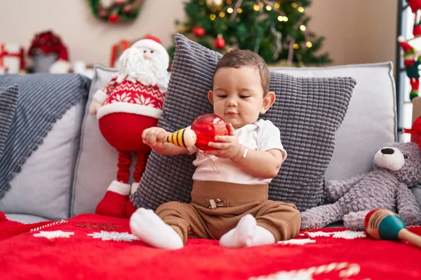 Adorable Hispanic Baby Holding Maraca Ball Sitting Sofa Christmas Tree — Stock Photo, Image