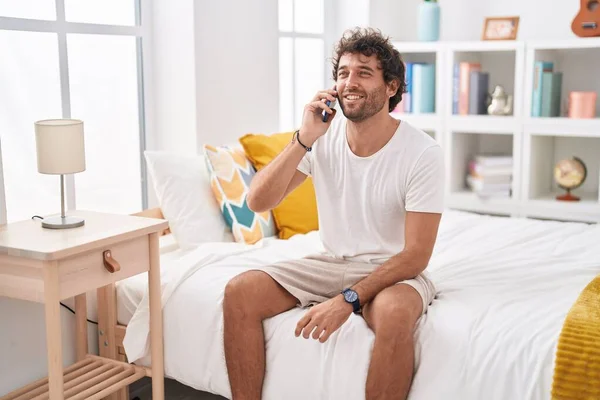 Hombre Hispano Joven Hablando Smartphone Sentado Cama Dormitorio —  Fotos de Stock