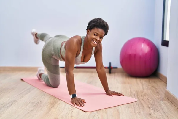 African american woman smiling confident training legs exersice at sport center