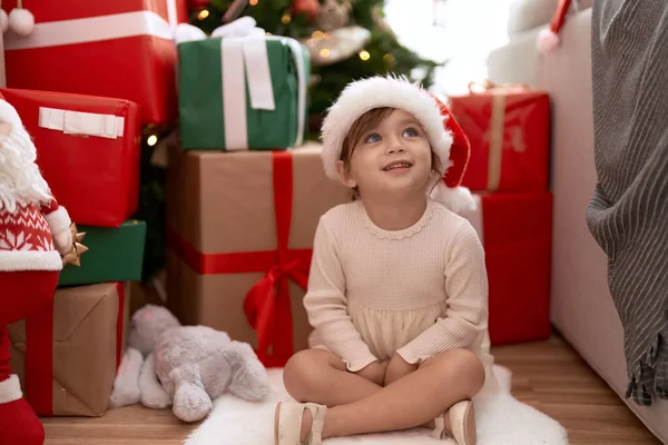 可爱的女孩微笑着 自信地坐在圣诞树旁和家中的礼物旁 — 图库照片