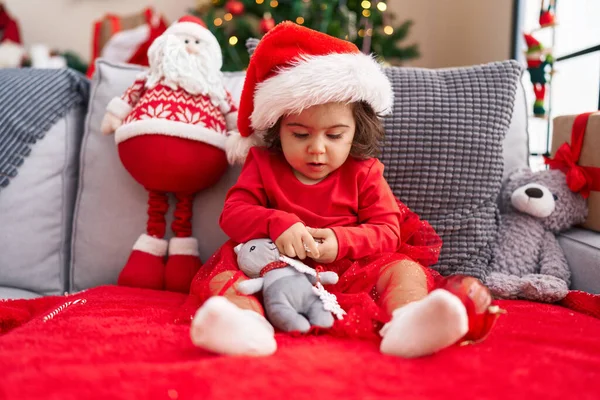 可爱的他惊慌失措的女儿坐在家里的圣诞树旁的沙发上 — 图库照片