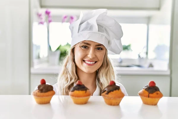 Giovane Donna Che Indossa Cuoco Uniforme Odore Cupcakes Cucina — Foto Stock