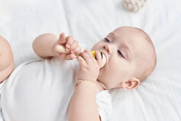 Sevimli Beyaz Bebek Yatakta Uzanıyor Yatak Odasında Maraca Oyuncağı Emiyor — Stok fotoğraf