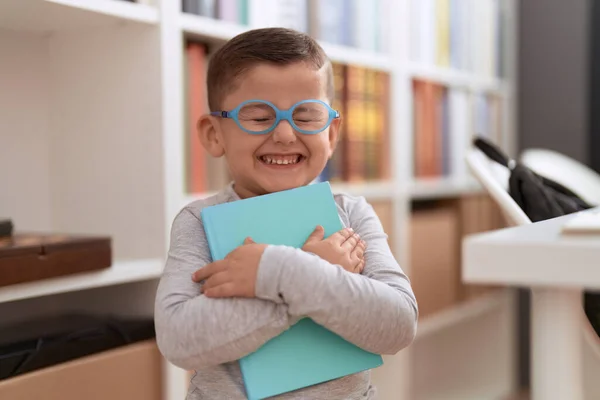 在图书馆学校 他那可爱的惊慌失措的孩子微笑着 自信地拿着书 — 图库照片