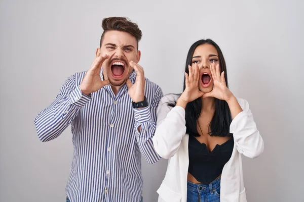 Young Hispanic Couple Standing White Background Shouting Angry Out Loud — ストック写真