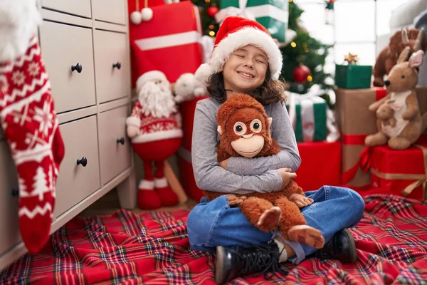Αξιολάτρευτο Κινεζάκι Αγκαλιάζει Μαϊμού Κούκλα Κάθεται Στο Πάτωμα Από Χριστουγεννιάτικο — Φωτογραφία Αρχείου