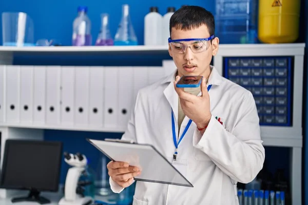 Young Man Scientist Talking Smartphone Reading Document Laboratory — Stock Photo, Image