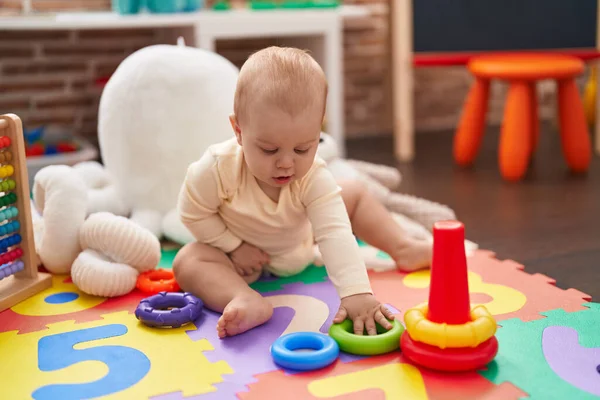 可爱的高加索婴儿在幼儿园的地板上玩圈圈玩具 — 图库照片