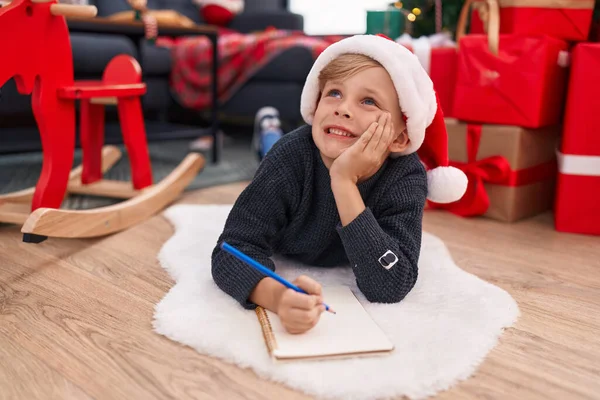 Adorable Niño Escribiendo Cuaderno Tumbado Junto Árbol Navidad Casa — Foto de Stock