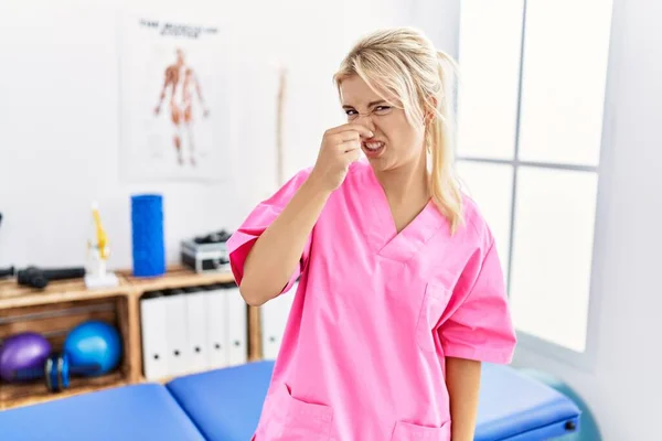 痛みの回復クリニックで働いている若い白人女性は 臭いと嫌な 耐えられない匂いを嗅ぎ 鼻に指で息をしています 臭いが悪い — ストック写真