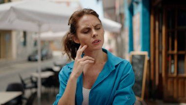 Sokakta şüpheli bir ifadeyle duran genç kadın.