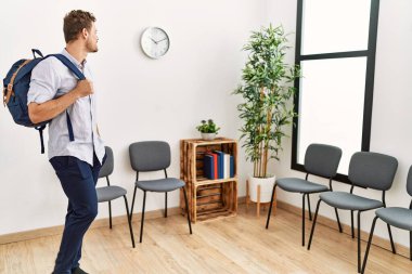 Sırt çantalı genç İspanyol adam bekleme odasında bekliyor.