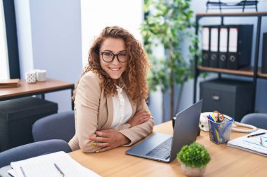 Young beautiful hispanic woman business worker using laptop working at office
